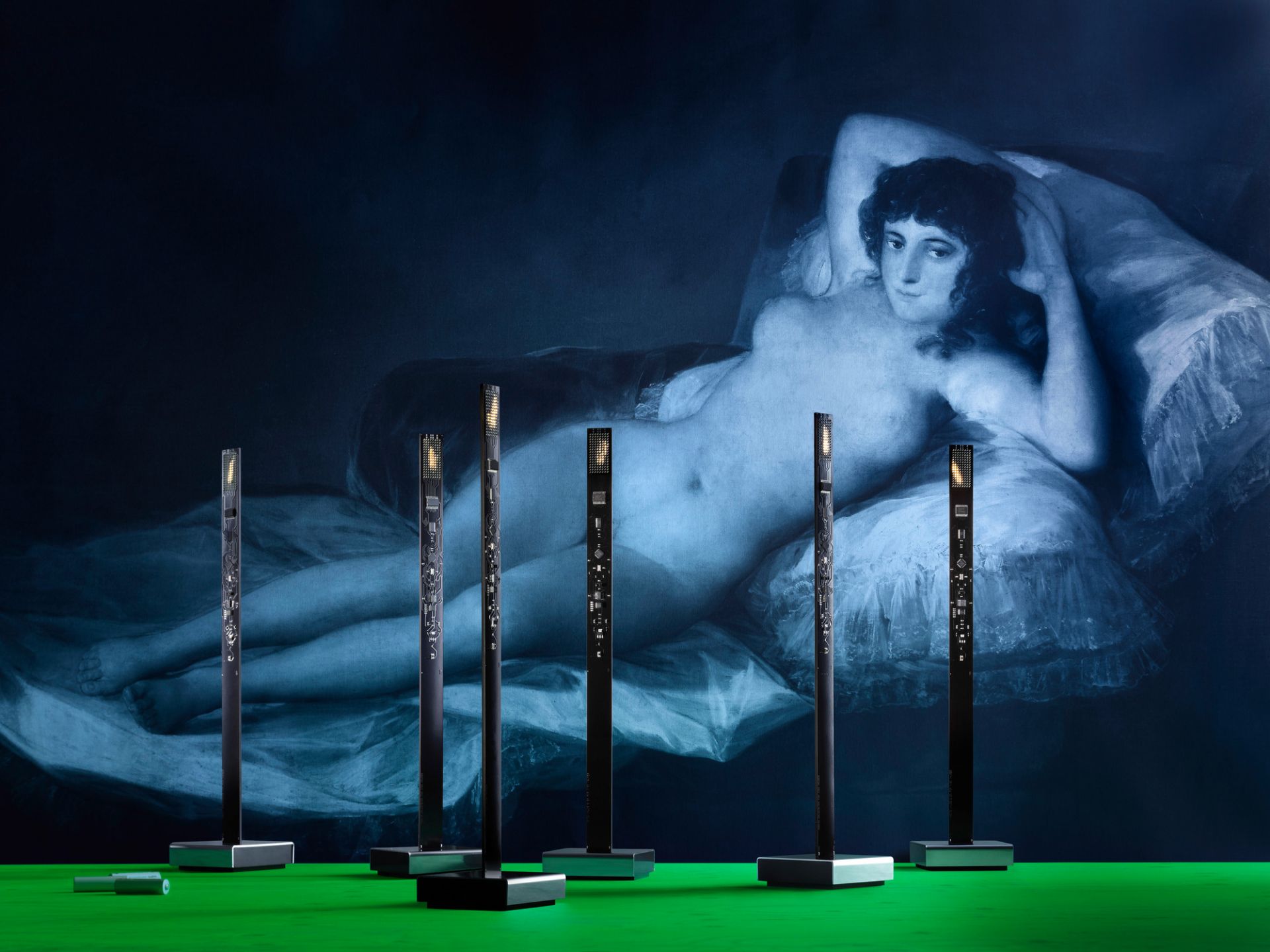 Mehrere Ingo Maurer My New Flame USB Tischlampen vor einem Gemälde, stimmungsvolle Beleuchtung.