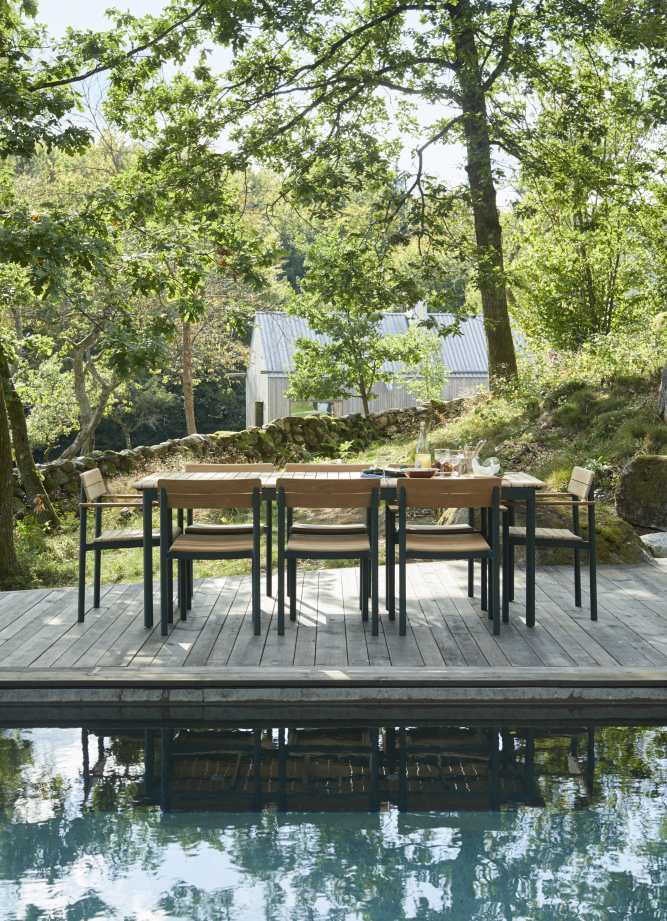 Pelagus Tisch von Skagerak by Fritz Hansen, ein Outdoor Tisch mit Stühlen am Pool.