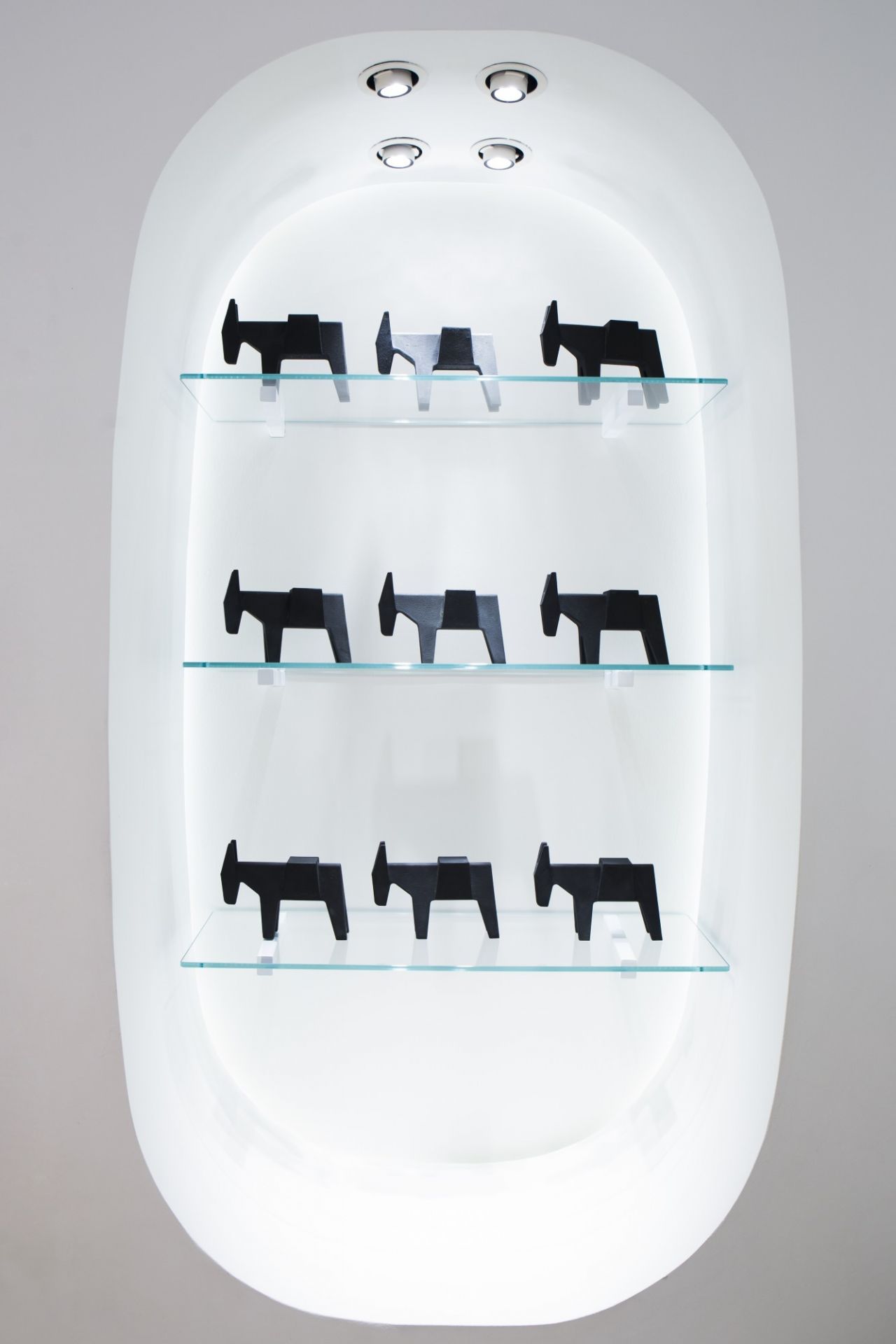 Regal mit mehreren Ettore Türstoppern von Magis in Form von Eseln, schwarz und grau.