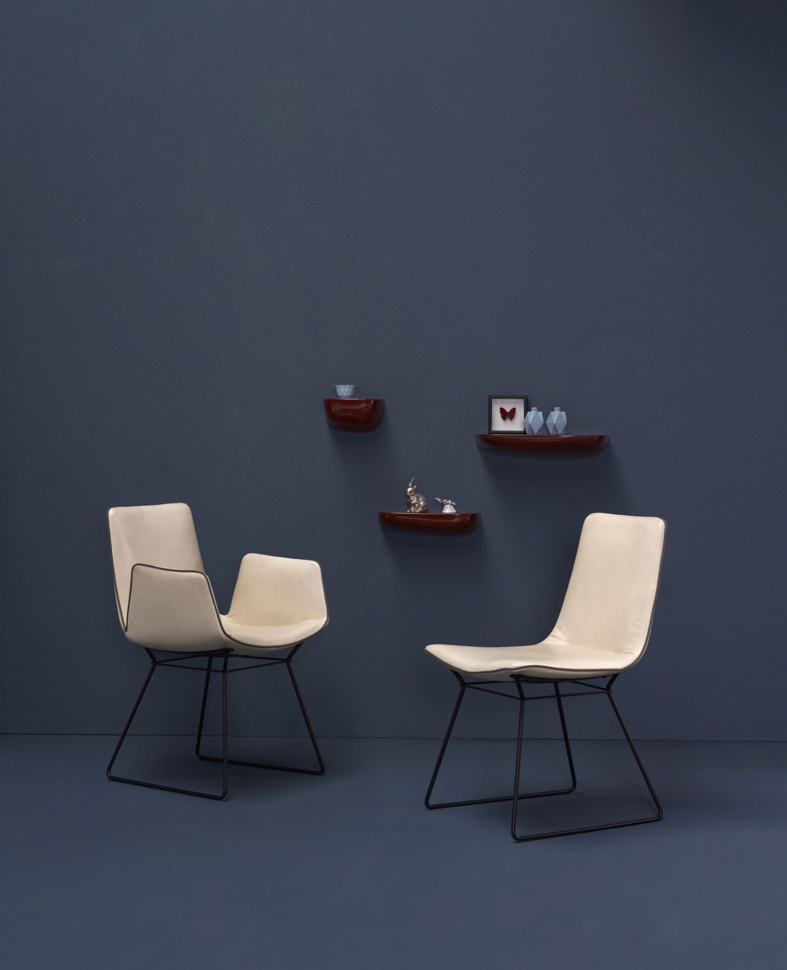 Zwei Amelie Armlehnstühle von Freifrau Manufaktur in Beige mit hohen Armlehnen und schwarzem Gestell.