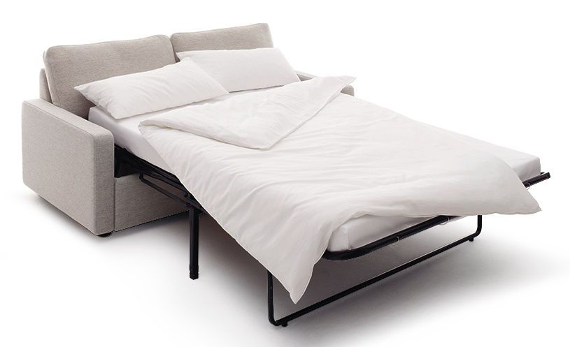 Conseta Schlafsofa Cor in Beige, ausgeklappt mit weißer Bettwäsche und Kissen, für komfortables Schlafen.