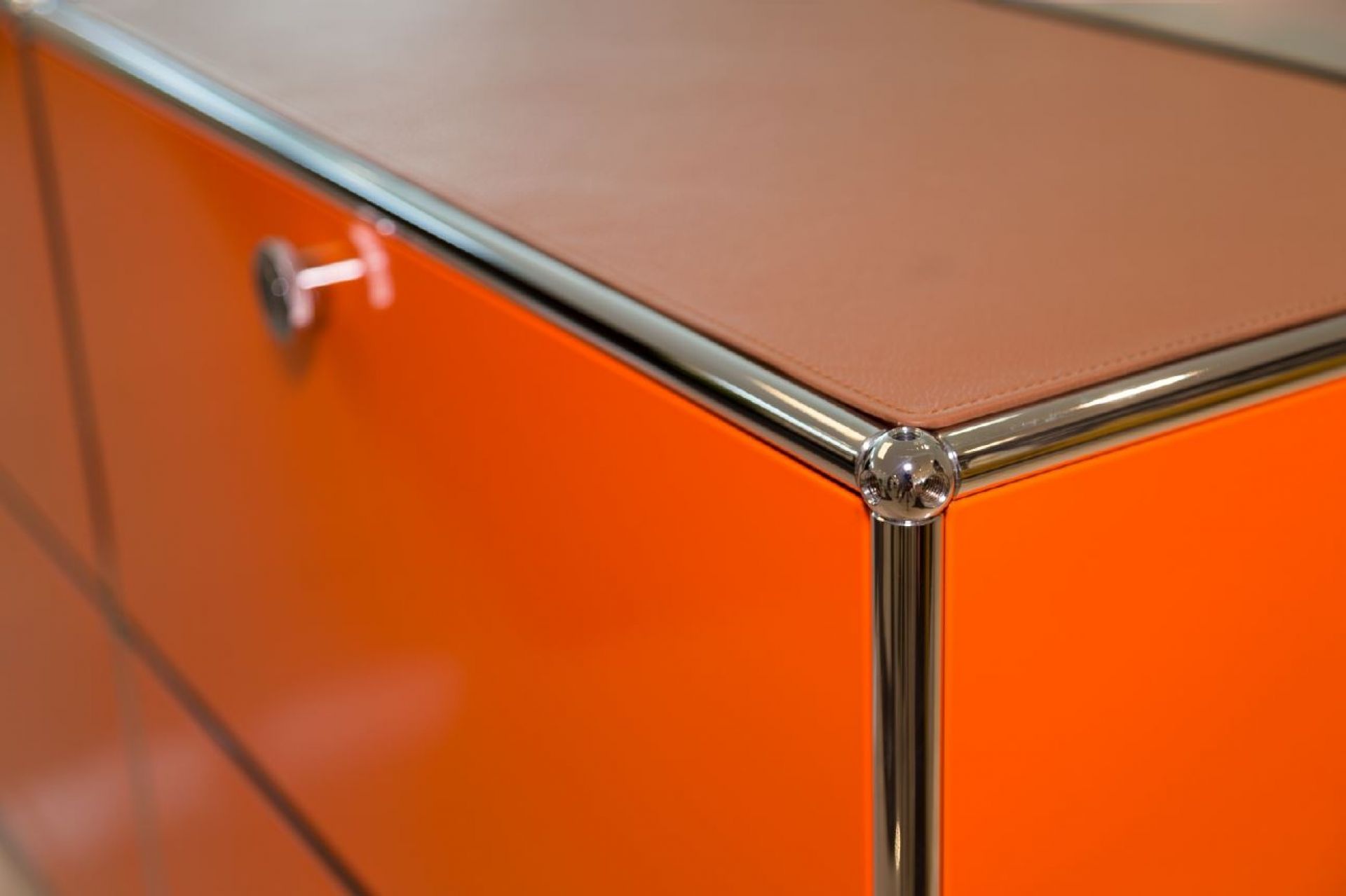 Detailaufnahme: USM Sideboard in Orange mit cognacfarbener Lederauflage "Leather on Top".