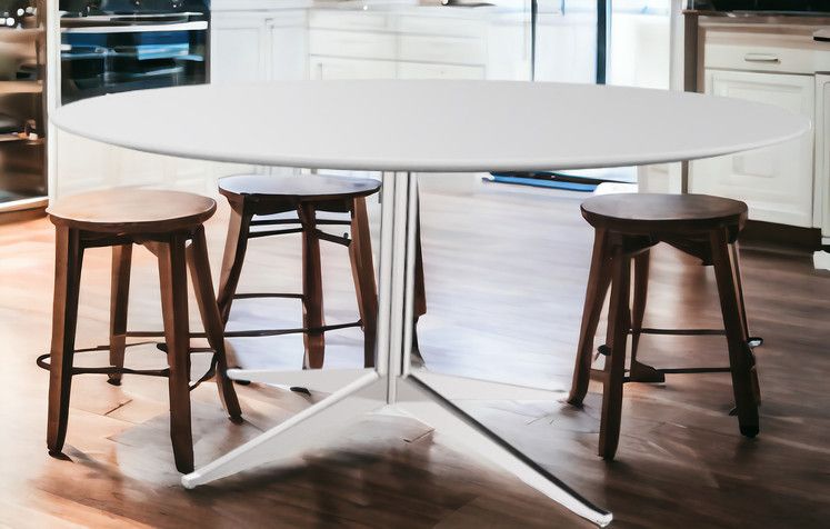 Florence Esstisch: Runder Tisch mit weißer Platte und modernem, weißem Untergestell, umgeben von Barhockern.