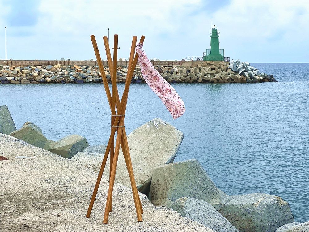 Mary Garderobenständer aus Eiche von Keilbach Designprodukte mit fünf Stäben vor Küstenkulisse. Moderner Garderobenständer für Flur und Schlafzimmer.