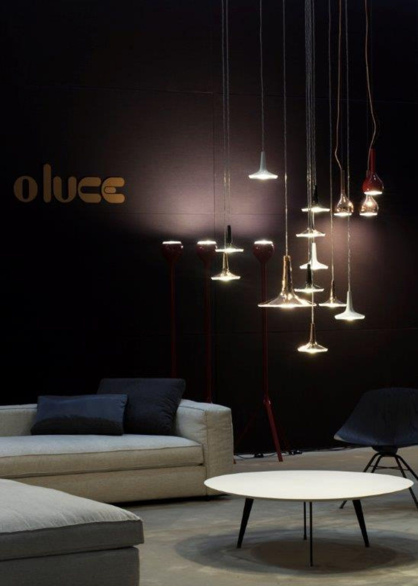 Kin LED Pendelleuchten von Oluce in verschiedenen Farben und Formen über einem Wohnzimmer.