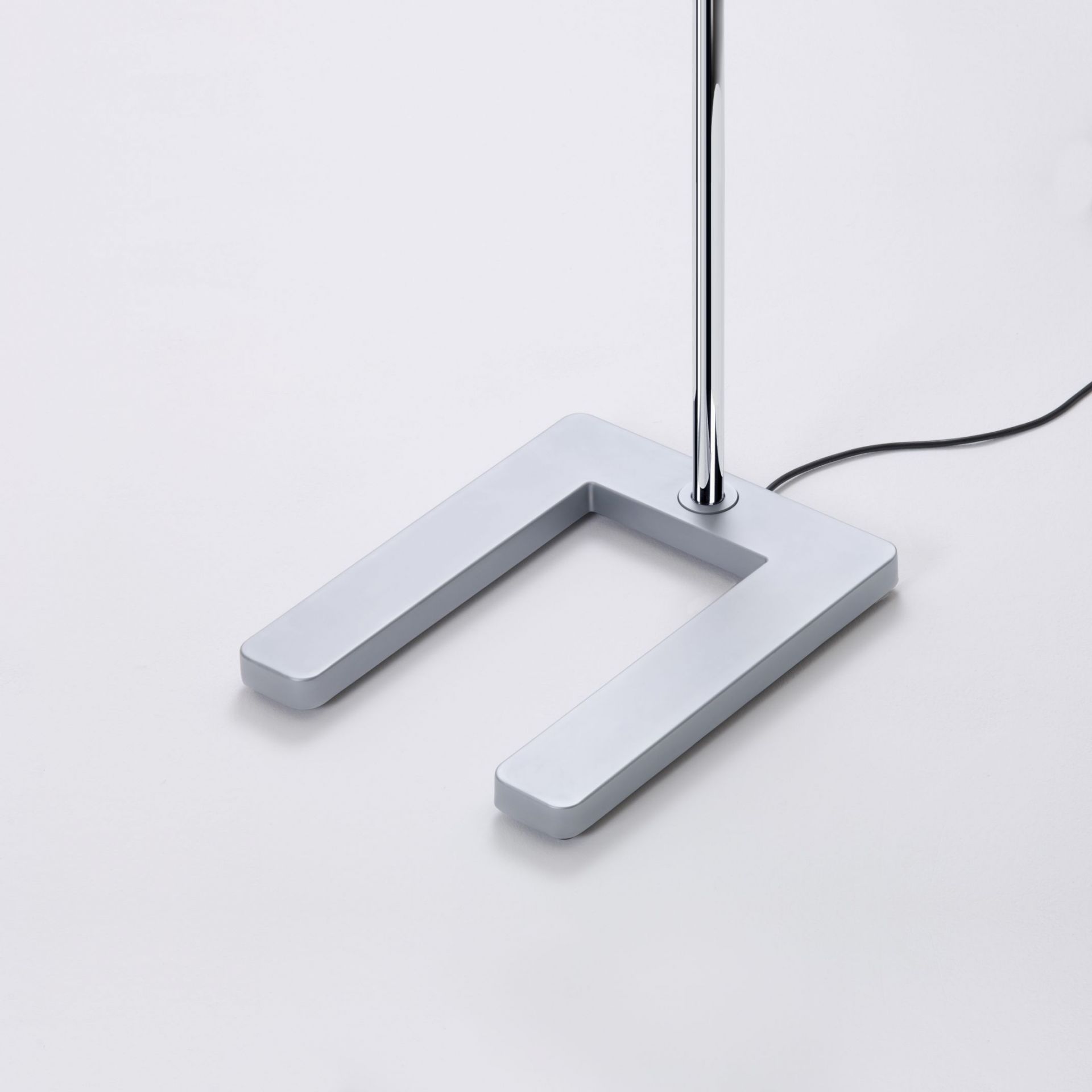 Detailaufnahme: Slice² Stehleuchte, glanzverchromt, mit Sensorik, Fokus auf U-förmigen Fuß.