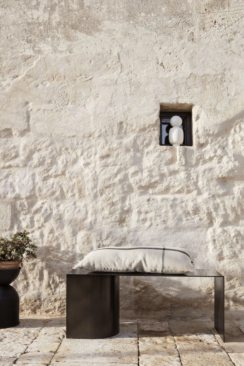 Nahaufnahme des Ferm Living Hourglass Pot (klein) mit Pflanze im Außenbereich.