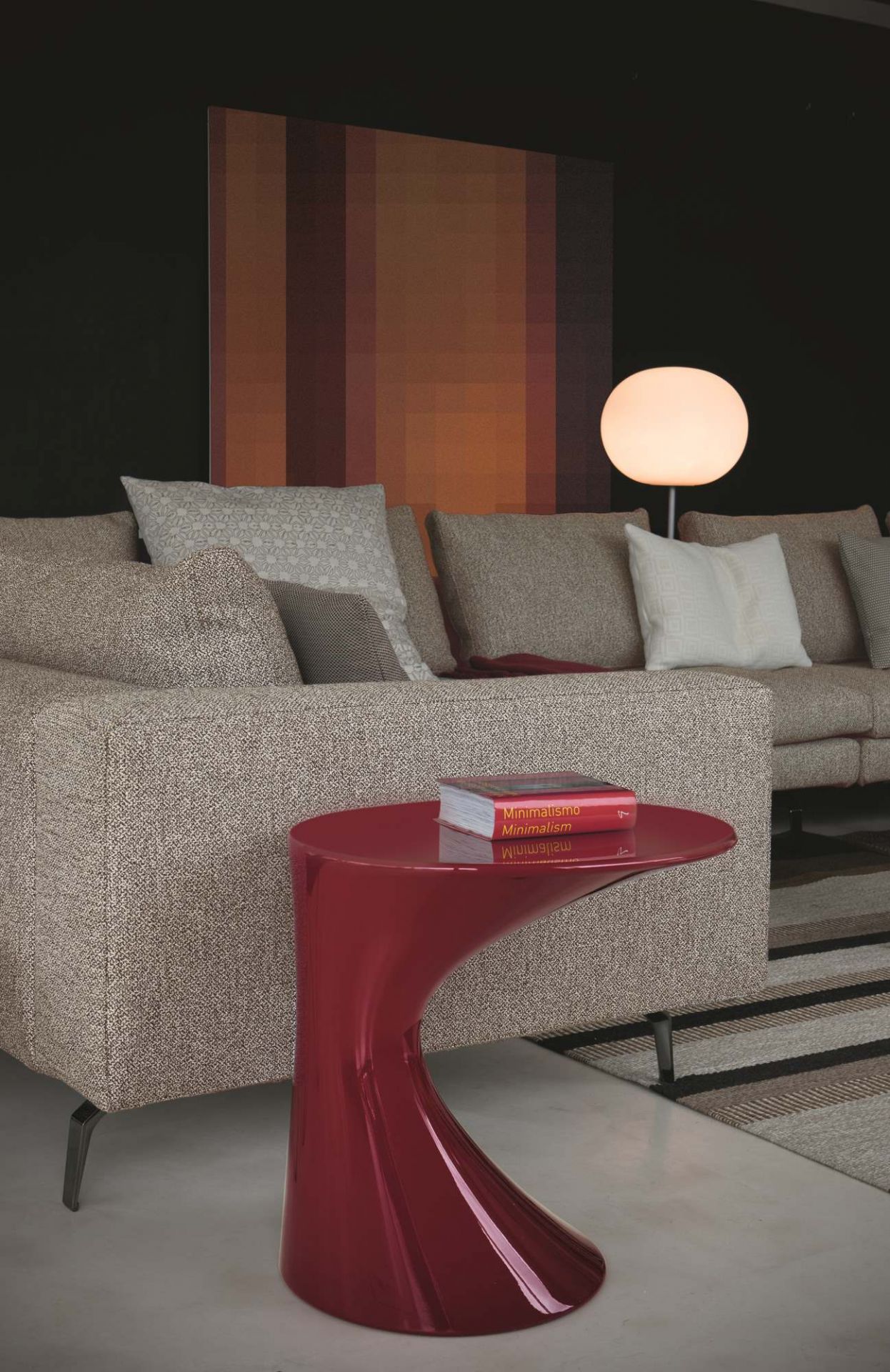 Roter Tod Couchtisch von Zanotta neben einem beigen Sofa mit Kissen und einem Buch.