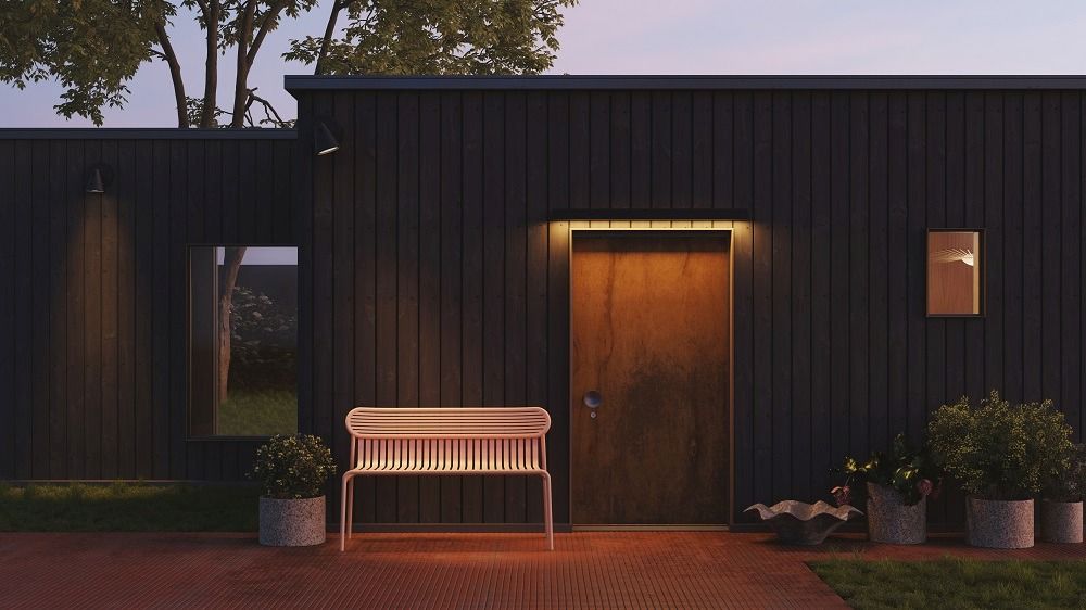 Petite Friture Week-End Gartenbank Terrakotta vor dunkler Holzwand und Tür, stimmungsvolle Gartenmöbel mit Rückenlehne.