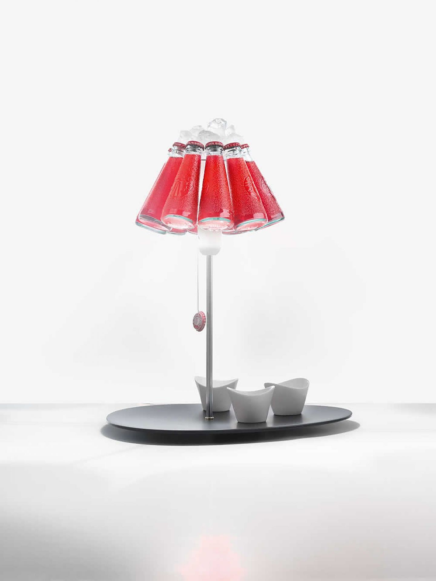 Campari Lampe: Ingo Maurer Tischleuchte mit Campari Flaschen als Lampenschirm und Eiswürfeln.