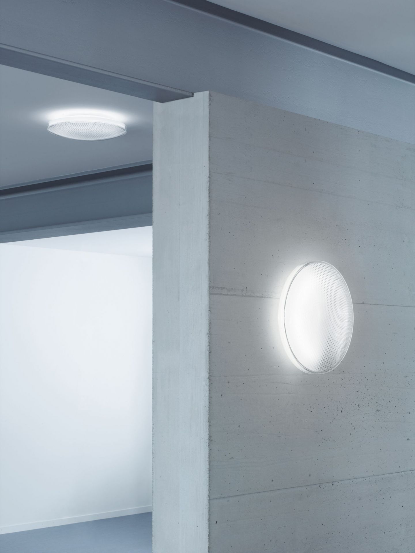 O-lite Wandleuchte an Betonwand und Deckenleuchte, warmweißes Licht, modernes Design für Innenräume.
