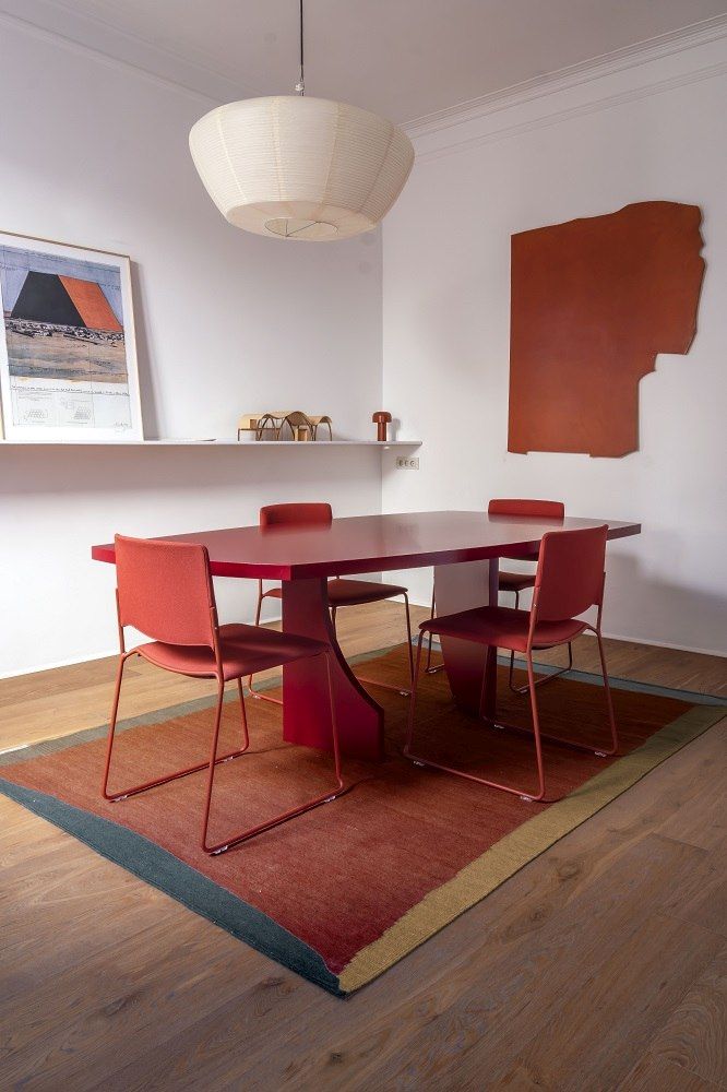 Nanimarquina Tones Collection Kilim Teppich im Esszimmer unter rotem Tisch und Stühlen, modernes Wohnambiente.