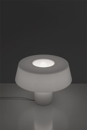 Weiße Amami Tischleuchte von Artemide mit sanftem Lichtschein für stimmungsvolle Beleuchtung.