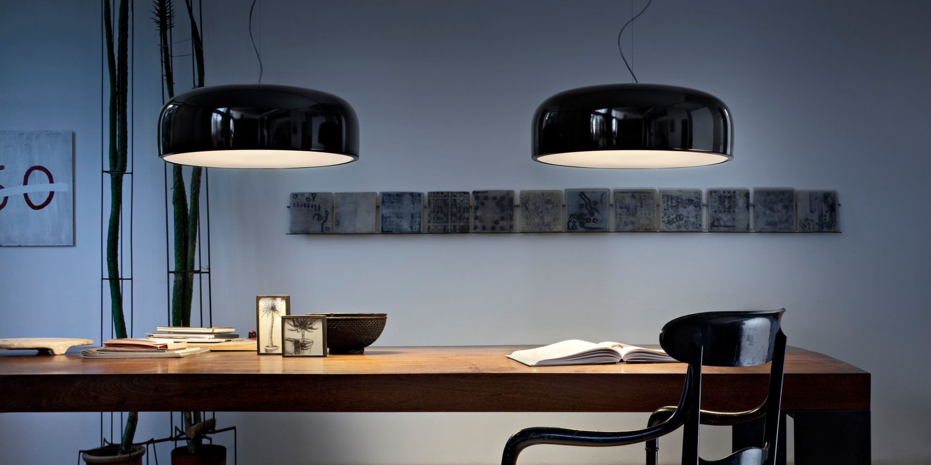 Zwei schwarze Smithfield Pendelleuchten von Flos über einem Holztisch in einem modernem Interieur.