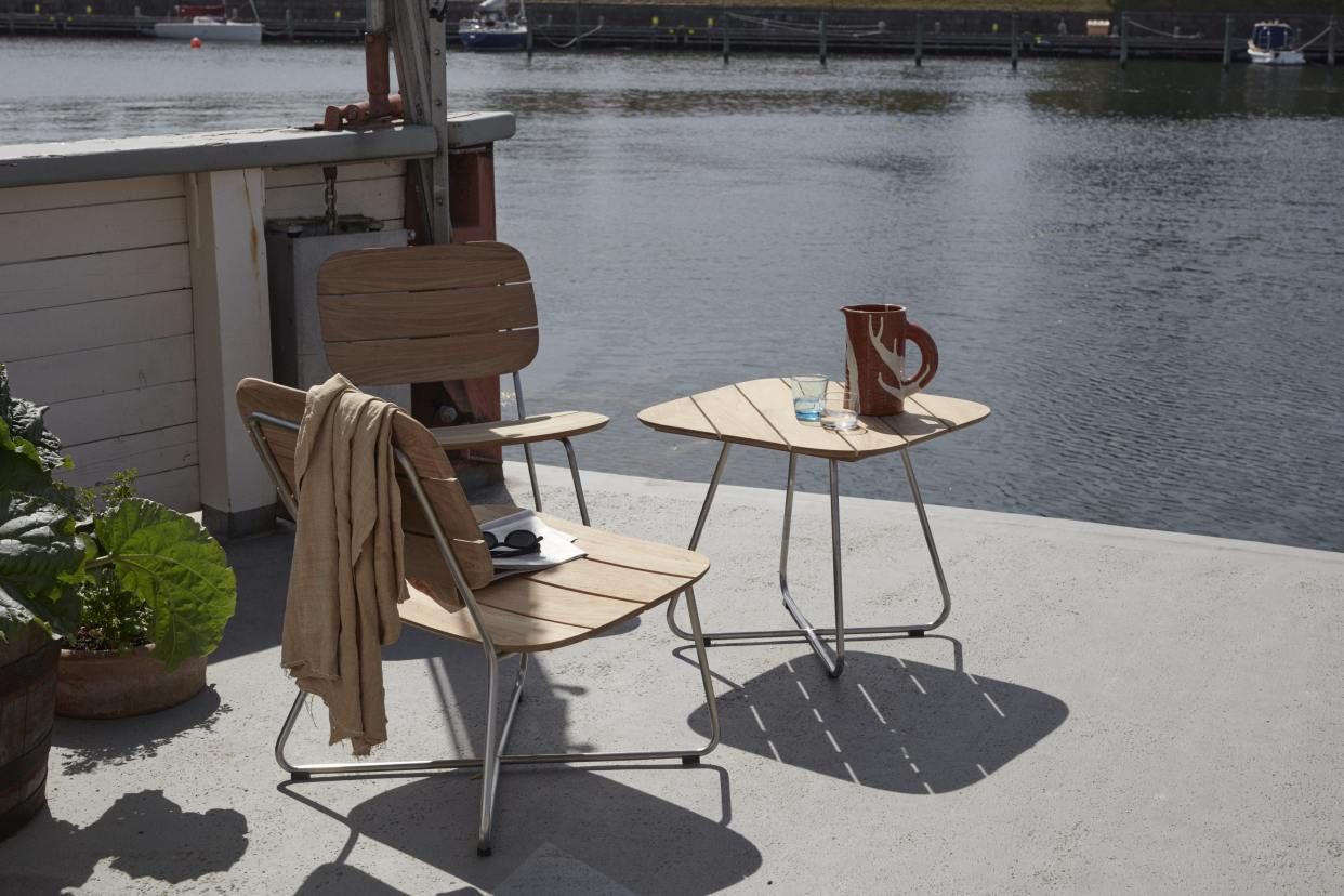 Lilium Lounge Table von Skagerak by Fritz Hansen mit Stühlen im Outdoor-Bereich am Wasser.