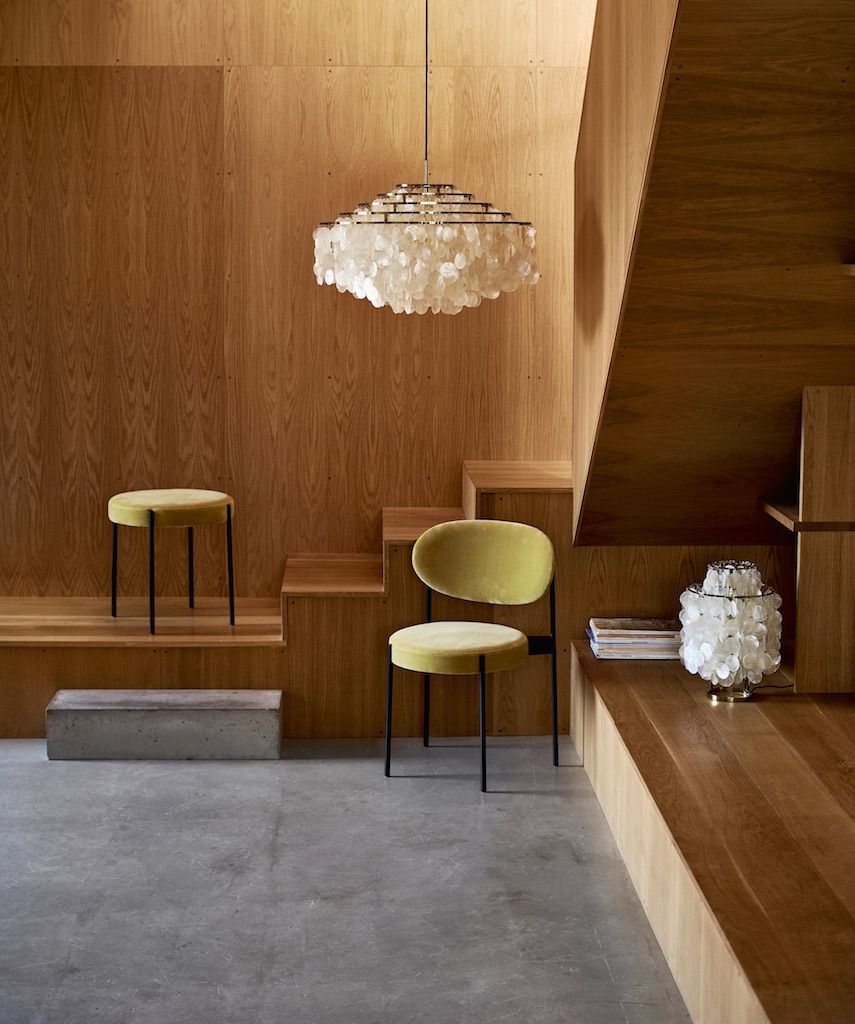 Gelber Verpan Series 430 Hocker und Stuhl in modernem Interieur mit Holzverkleidung.