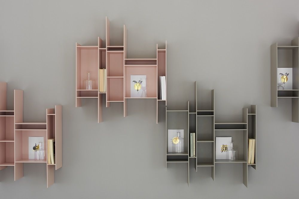 Farbiges Randomito Regalsystem von MDF Italia an einer Wand, mit Büchern und Dekoration.