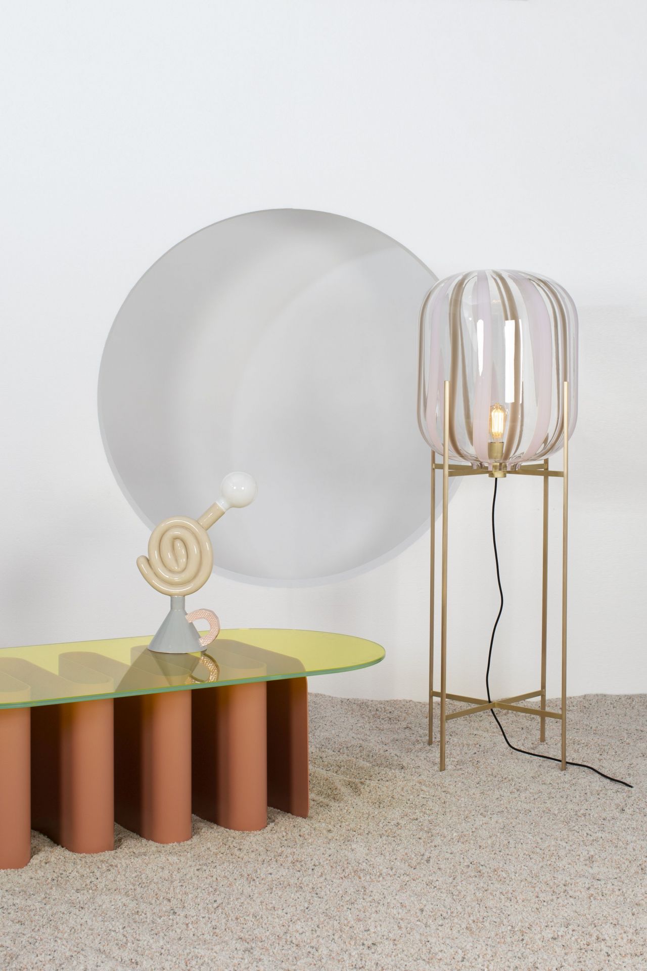 Tavolo2 Esstisch von Pulpo mit gelber Glasplatte und rosa Säulen, dazu eine Stehlampe.