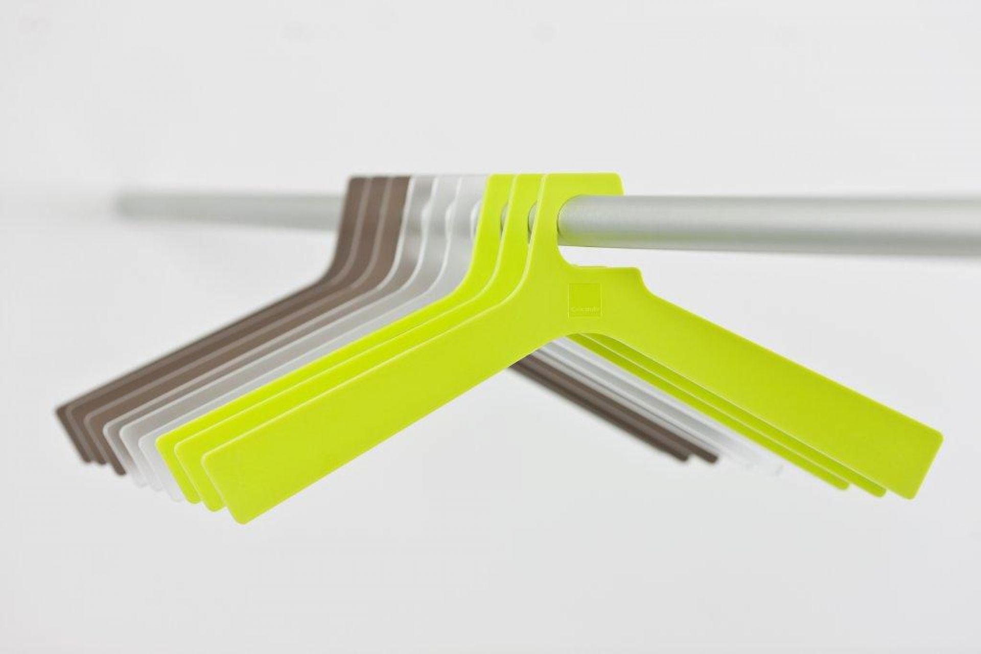 Forest Kleiderständer von Cascando: Mehrfarbige Kleiderbügel aus Kunststoff hängen an einer Stange.