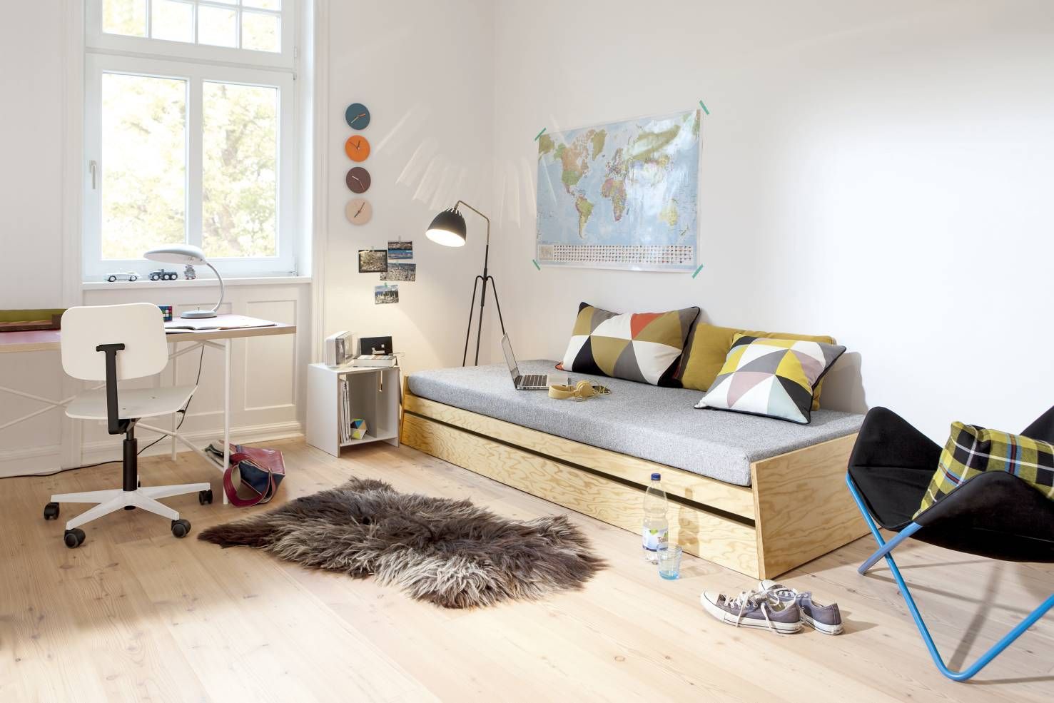 Zimmeransicht mit Richard Lampert Alu Alu Wanduhr in Pfirsich- und Pastelltönen an der Wand.