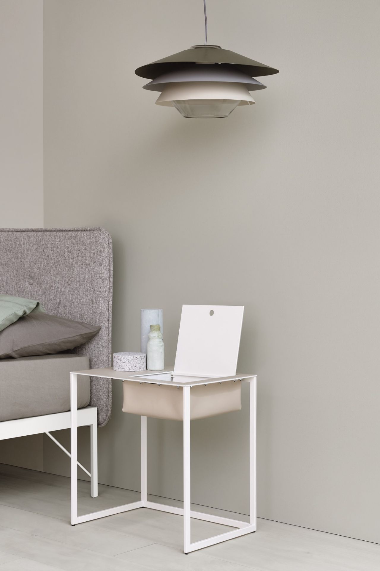 Moderner Nachttisch Taschino von Zanotta in Weiß mit Ablagefach neben einem Bett.