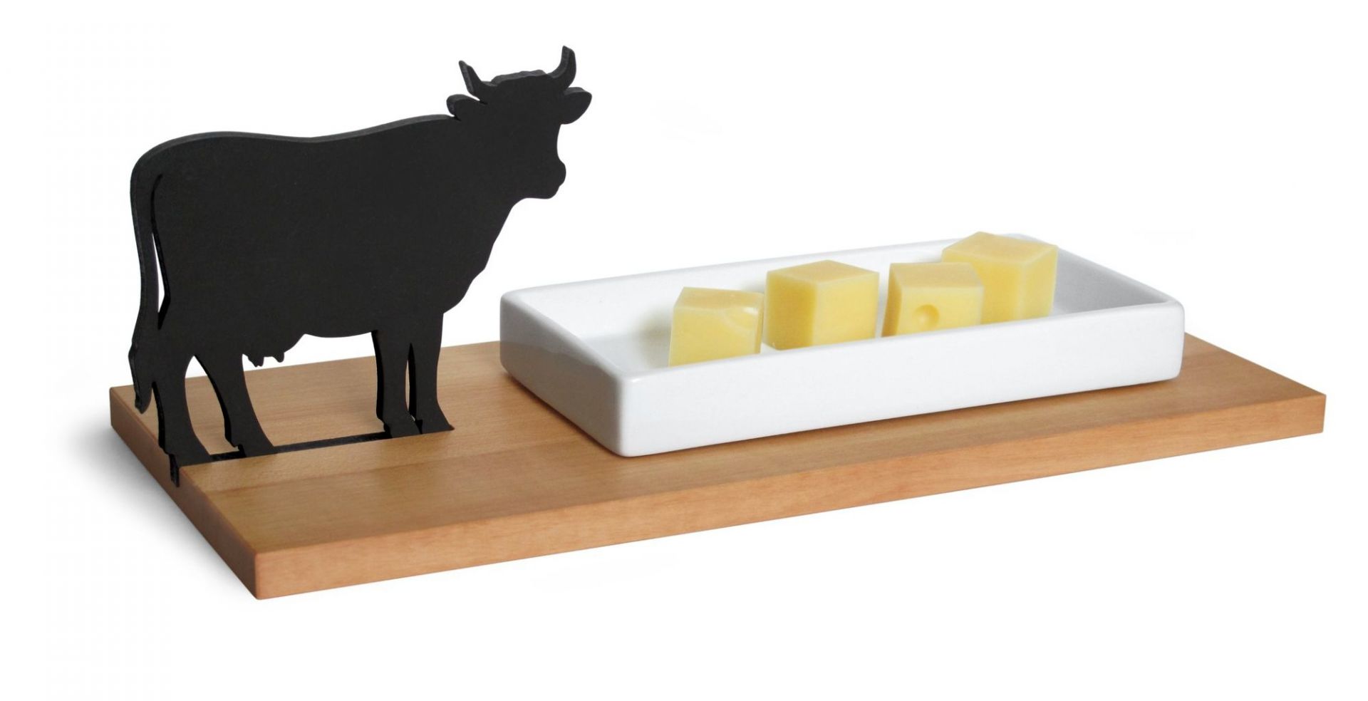 Käseschale mit Kuh-Motiv: Holzbrett mit weißer Schale und Käsewürfeln, dekorative Käseplatte.