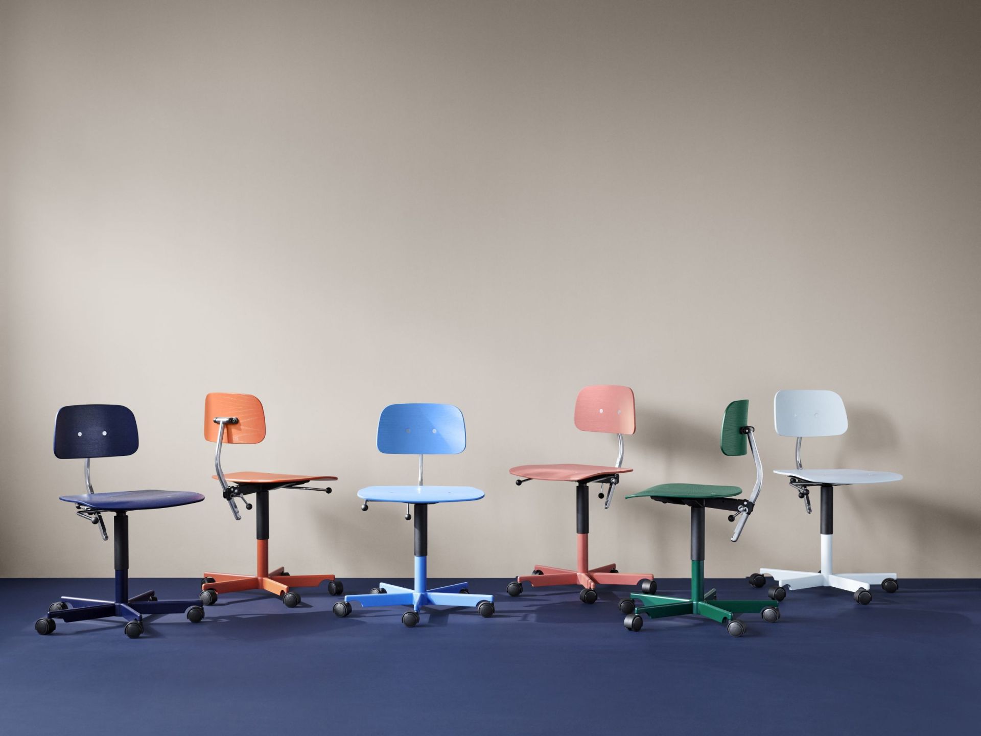 Reihe farbenfroher Kevi Bürostühle mit Rollen, ideal für Büro und Homeoffice. Ergonomisch und modern.