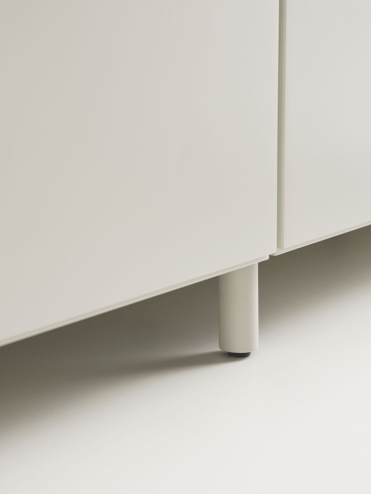 Detailaufnahme: Graue Kommode mit Relief Beine von String Furniture. Möbeldesign für Wohnzimmer.