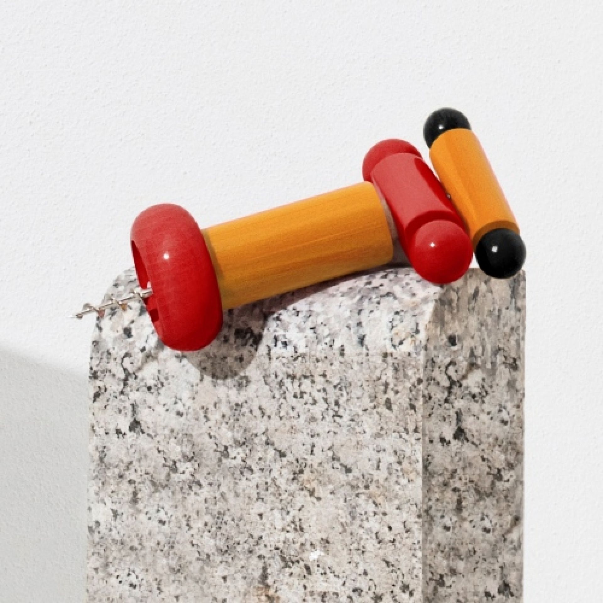 Alessi Korkenzieher ES17, ein farbenfrohes Einzelstück in Schwarz, Gelb und Weiß, auf einem Steinsockel.