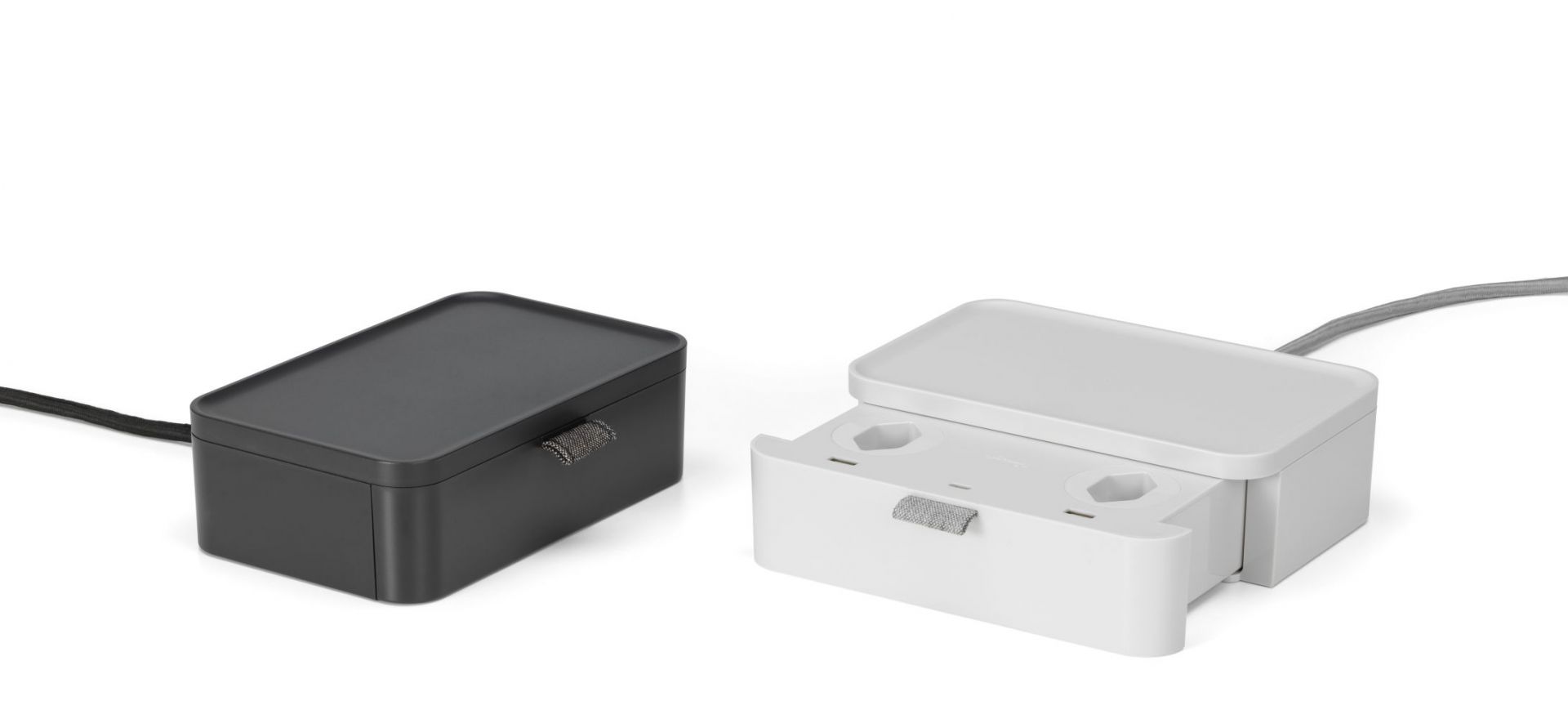 Ampi Wireless Charger und Vitra Mehrfachsteckdose in Schwarz und Weiß auf weißem Hintergrund.