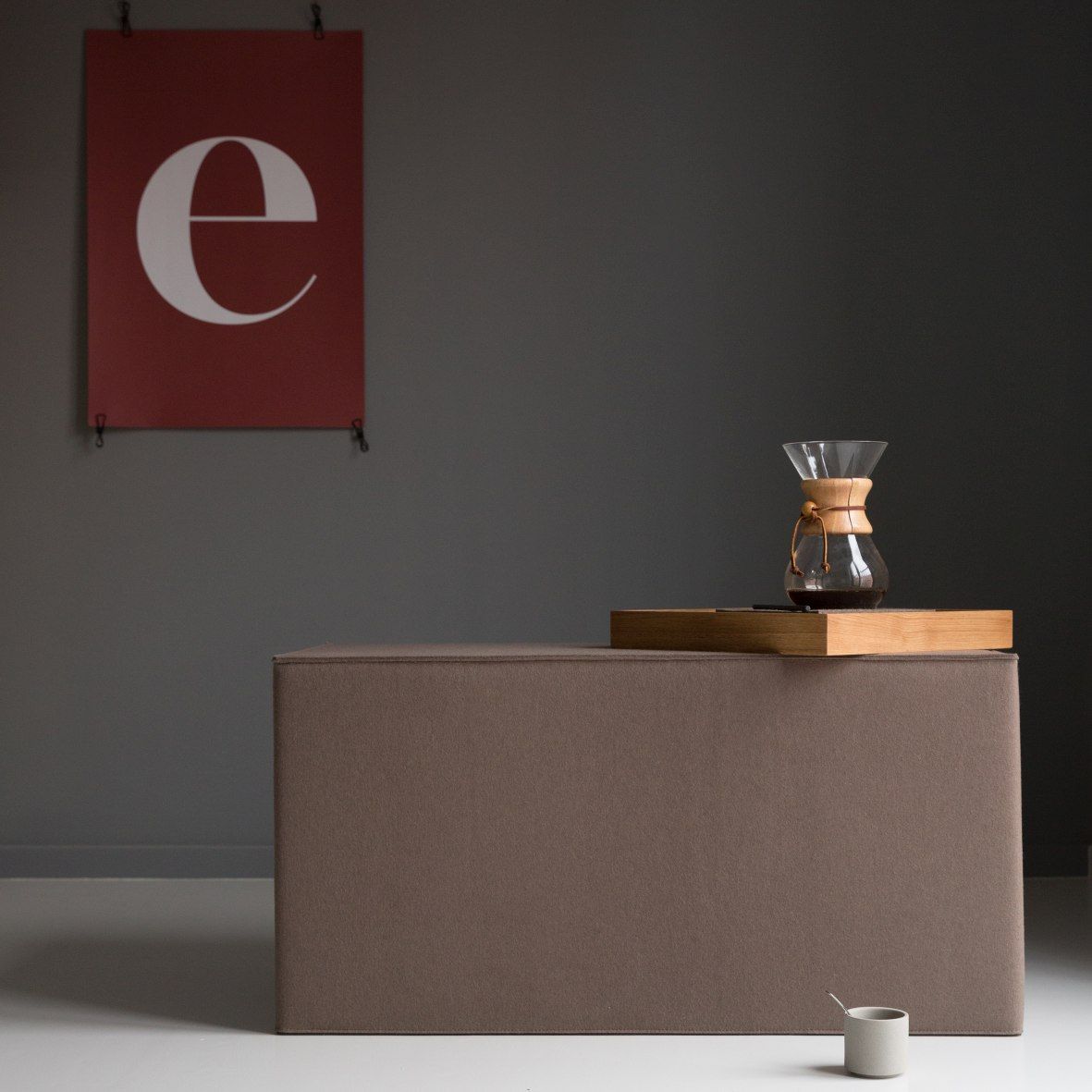 Brauner Quader Sitzhocker von Hey Sign mit Kaffeebereiter und Tasse im minimalistischen Raum.