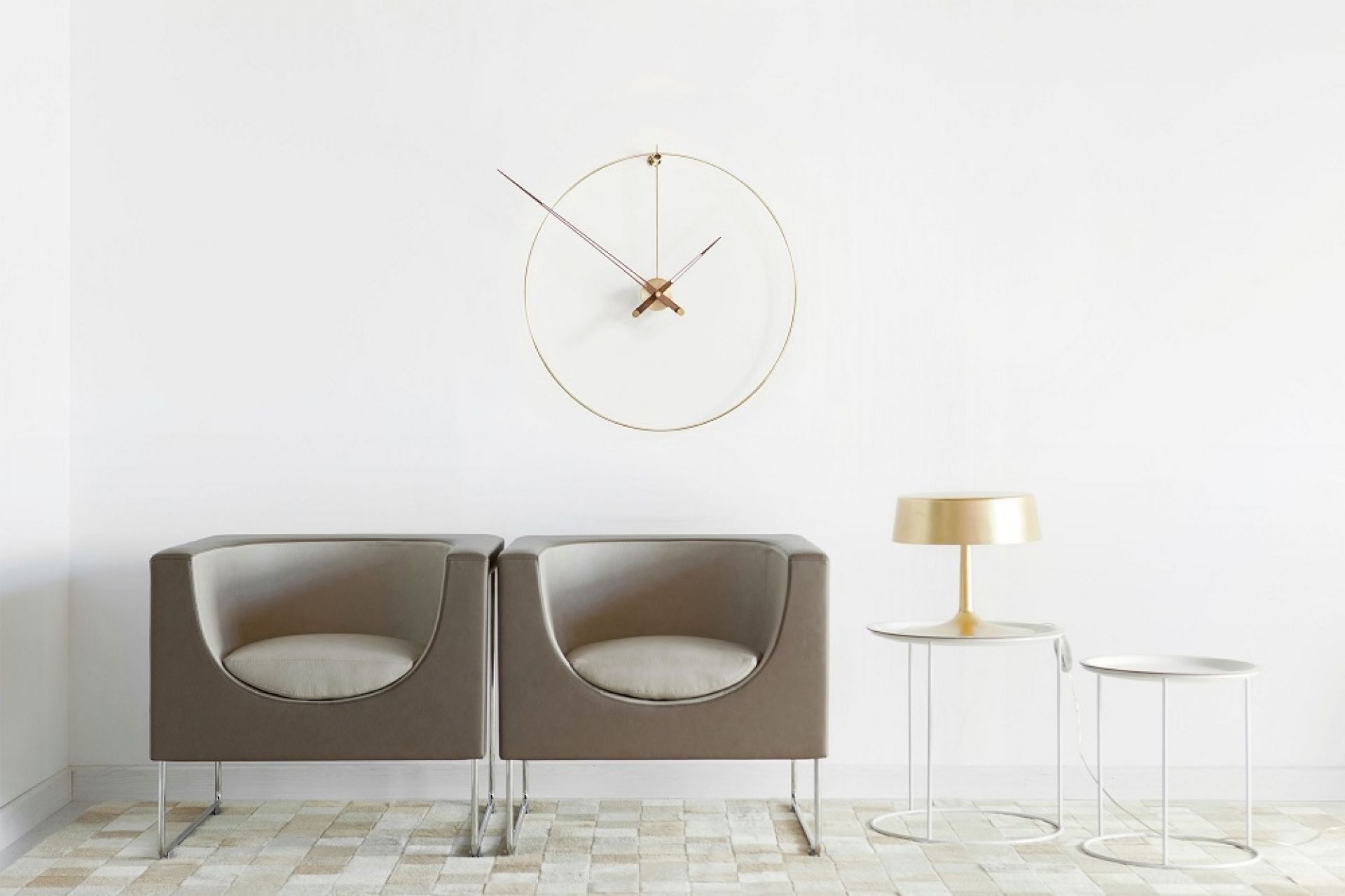 New Anda G Wanduhr von Nomon aus Messing in modernem Wohnzimmer mit Sesseln.