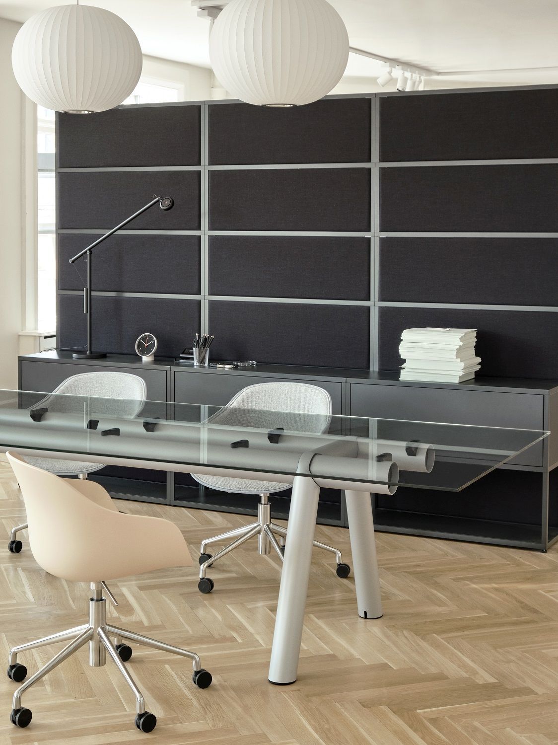 Büro mit Hay AAC 252 Stuhl, Glas-Tisch und grauem Sideboard im modernen Design.