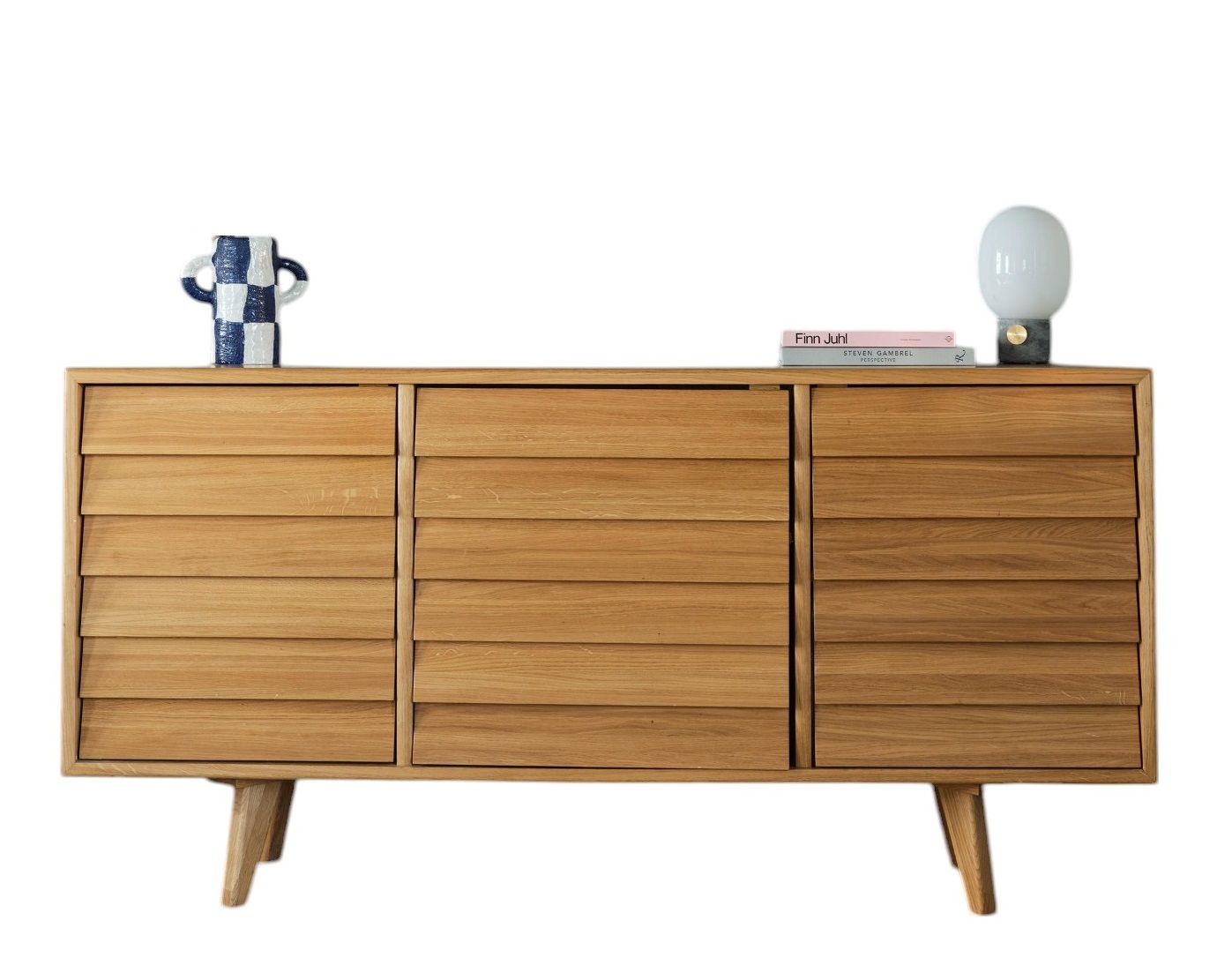 The Hansen Family Sideboard aus hellem Holz mit horizontalen Lamellen und Deko-Elementen.