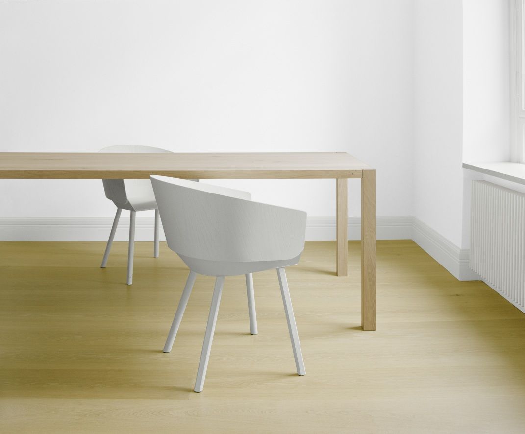 TA19 Sloane Tisch von e15 mit weißen Stühlen in einem hellen, modernen Esszimmer.