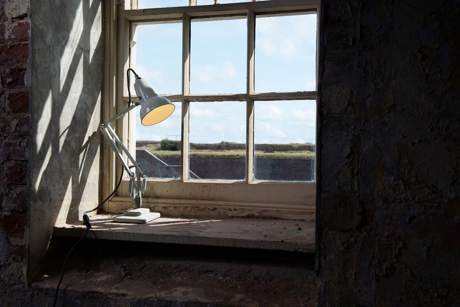 Anglepoise Original 1227 Mini Tischleuchte in Leinen Weiß auf einer Fensterbank, Design-Klassiker.
