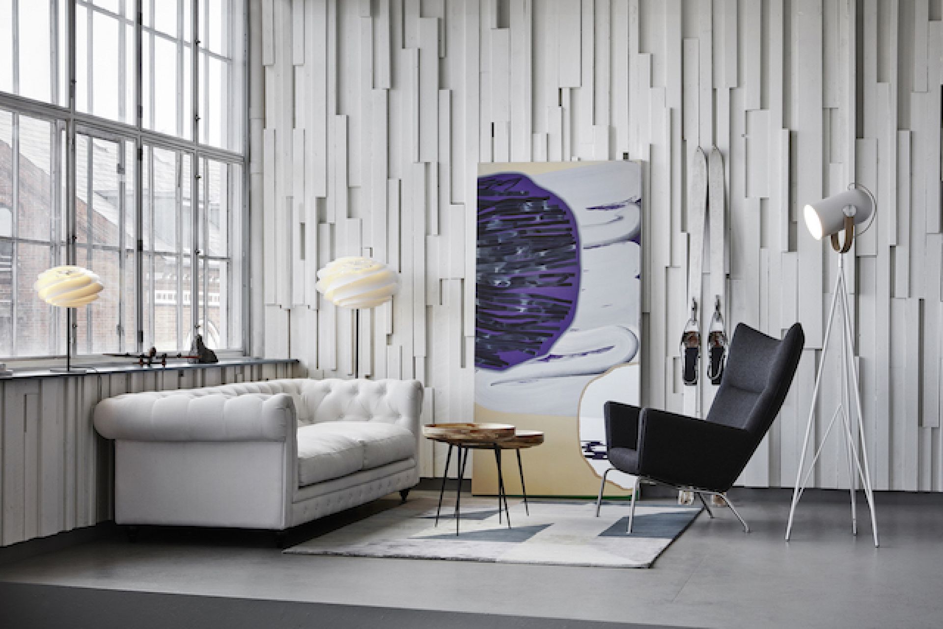 Swirl Stehleuchte von Le Klint in modernem Wohnzimmer mit Designermöbeln und Kunst.