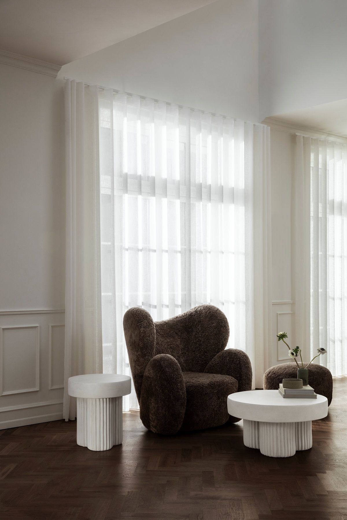 Brauner Little Big Pouf Hocker von NORR11 im Wohnzimmer mit weißen Beistelltischen.