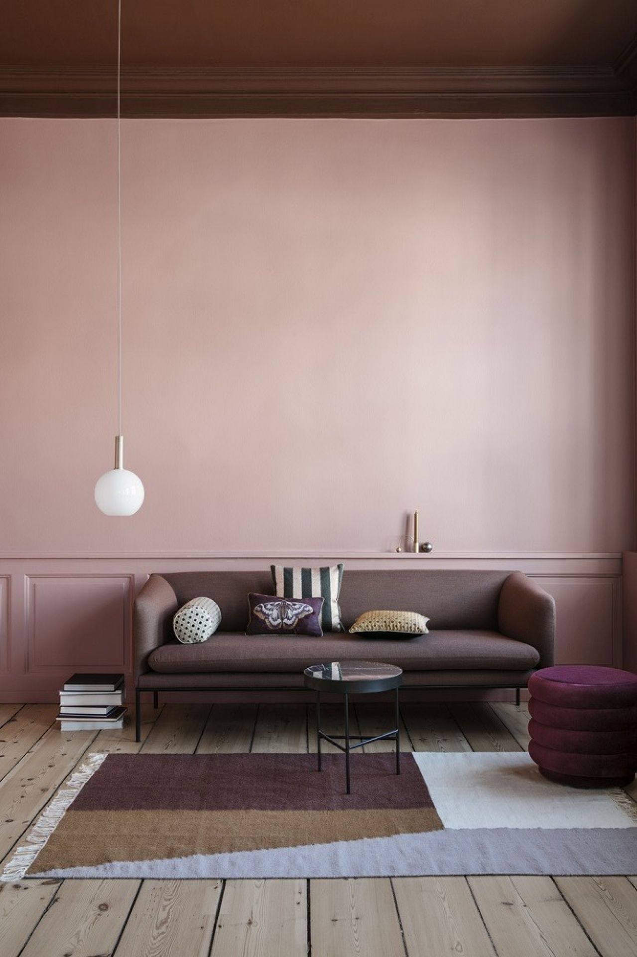 Wohnzimmer mit Ferm Living Marmor Beistelltisch, Sofa, Teppich und rosa Wandfarbe.