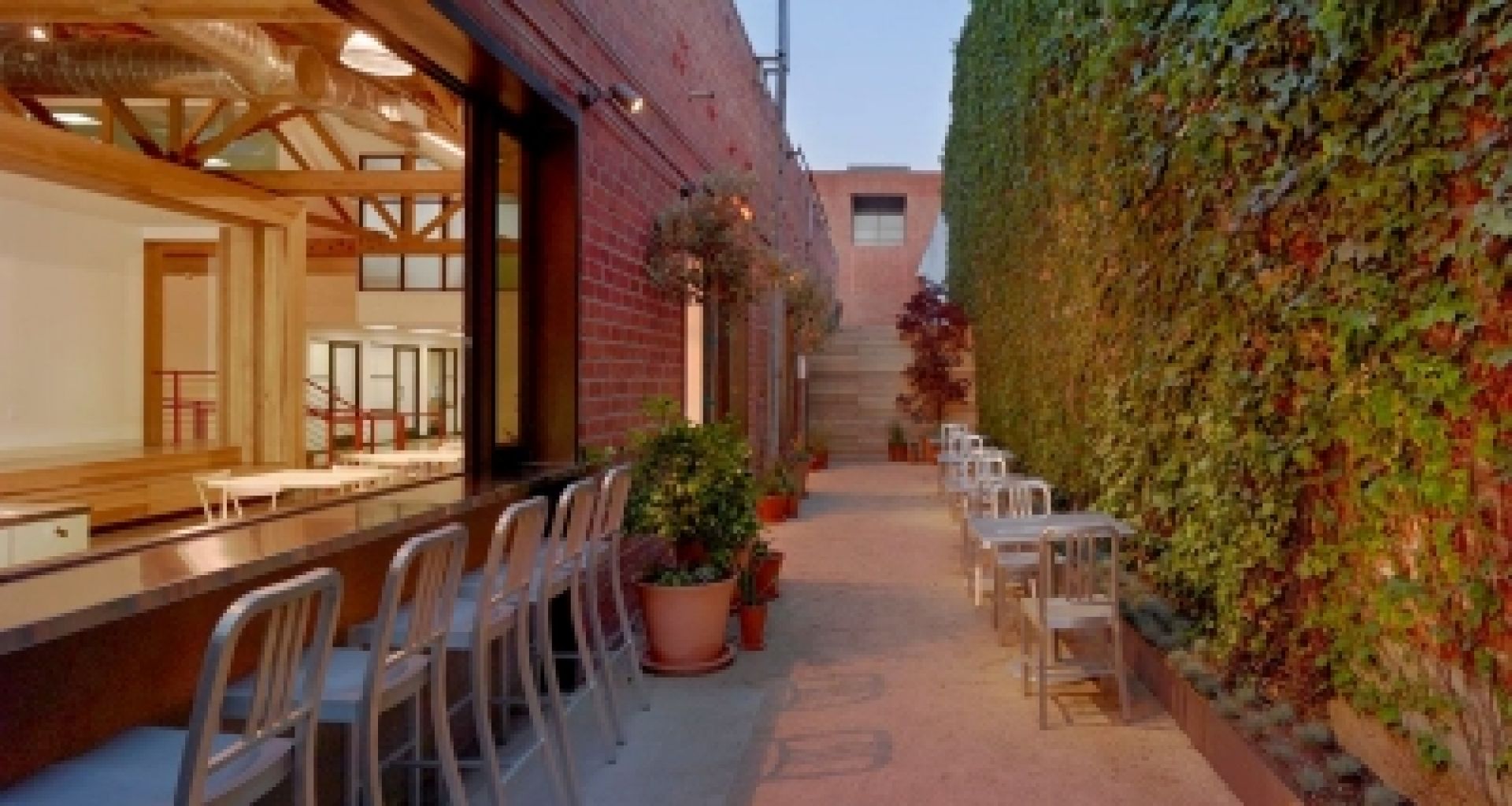 Emeco Navy Barhocker in Navy vor einer Bar, Sitzmöbel aus Aluminium für Gastronomie und Zuhause.