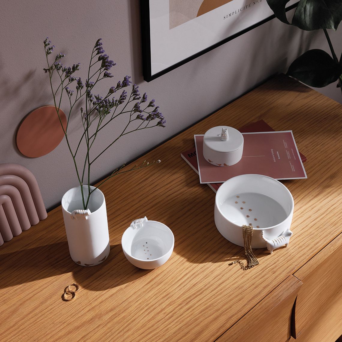 Nahaufnahme der Räder Vogelschwarm Porzellangeschichten Vase mit Trockenblumen und passenden Schalen auf einem Holztisch.