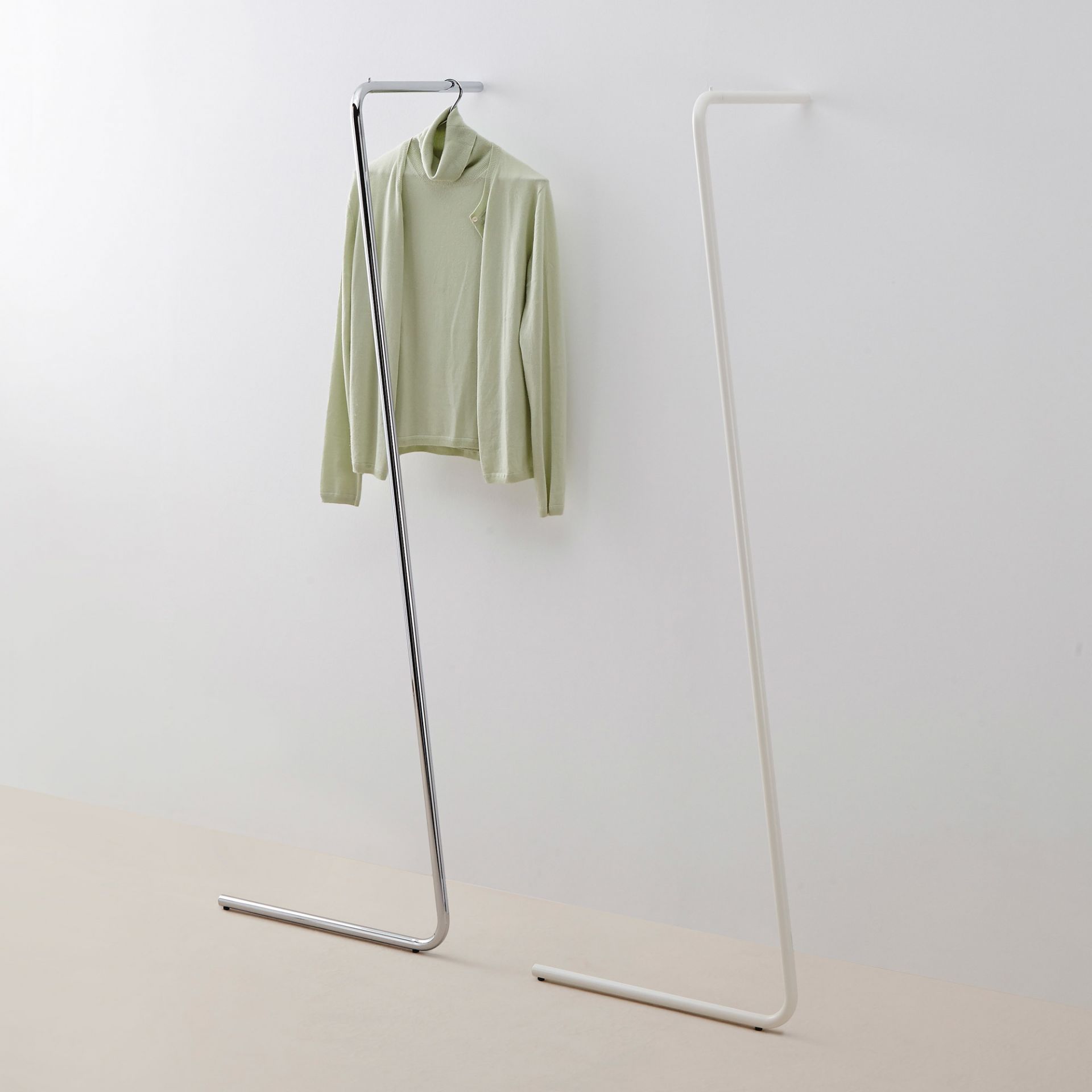 Sam Anlehngarderobe von Mox, zwei minimalistische Garderoben in Chrom und Weiß, eine mit Pullover.