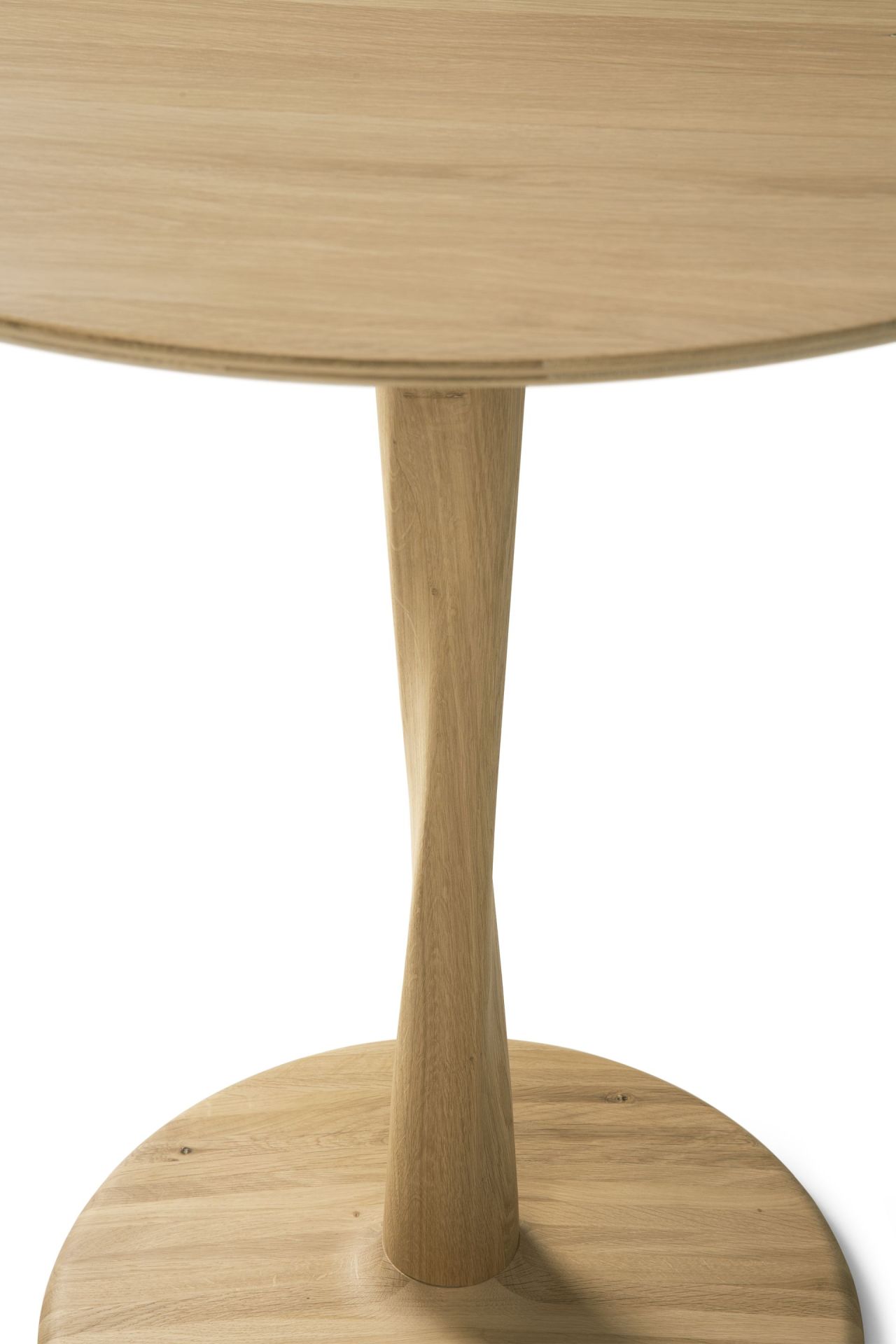 Detailaufnahme des Ethnicraft Torsion Tisches: Runder Eichentisch mit gedrehtem Sockel, lackiert und modern.