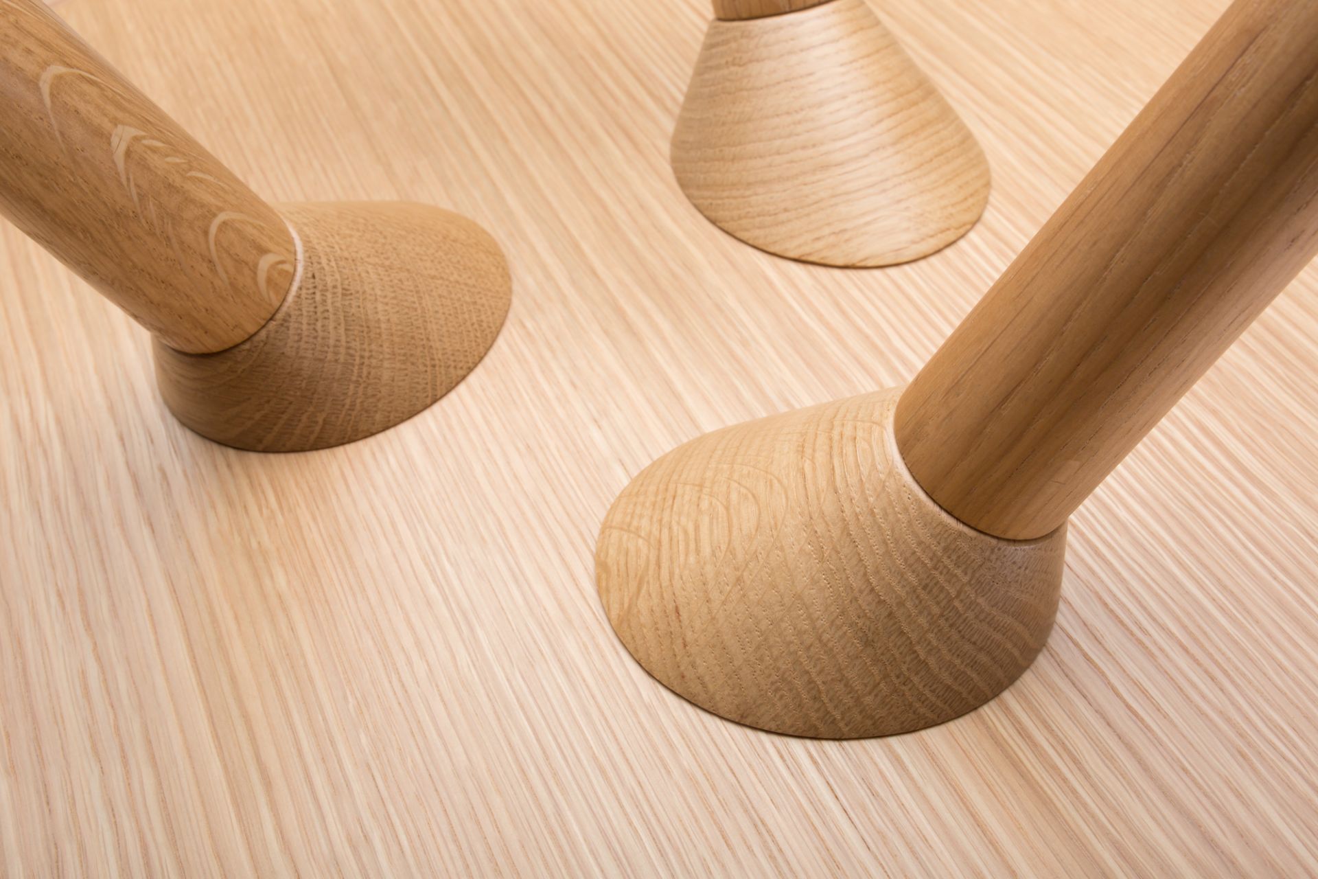 Detailaufnahme der Holzbeine des Maigrau Turn low Beistelltisches in Esche weiß, modernes Möbeldesign.