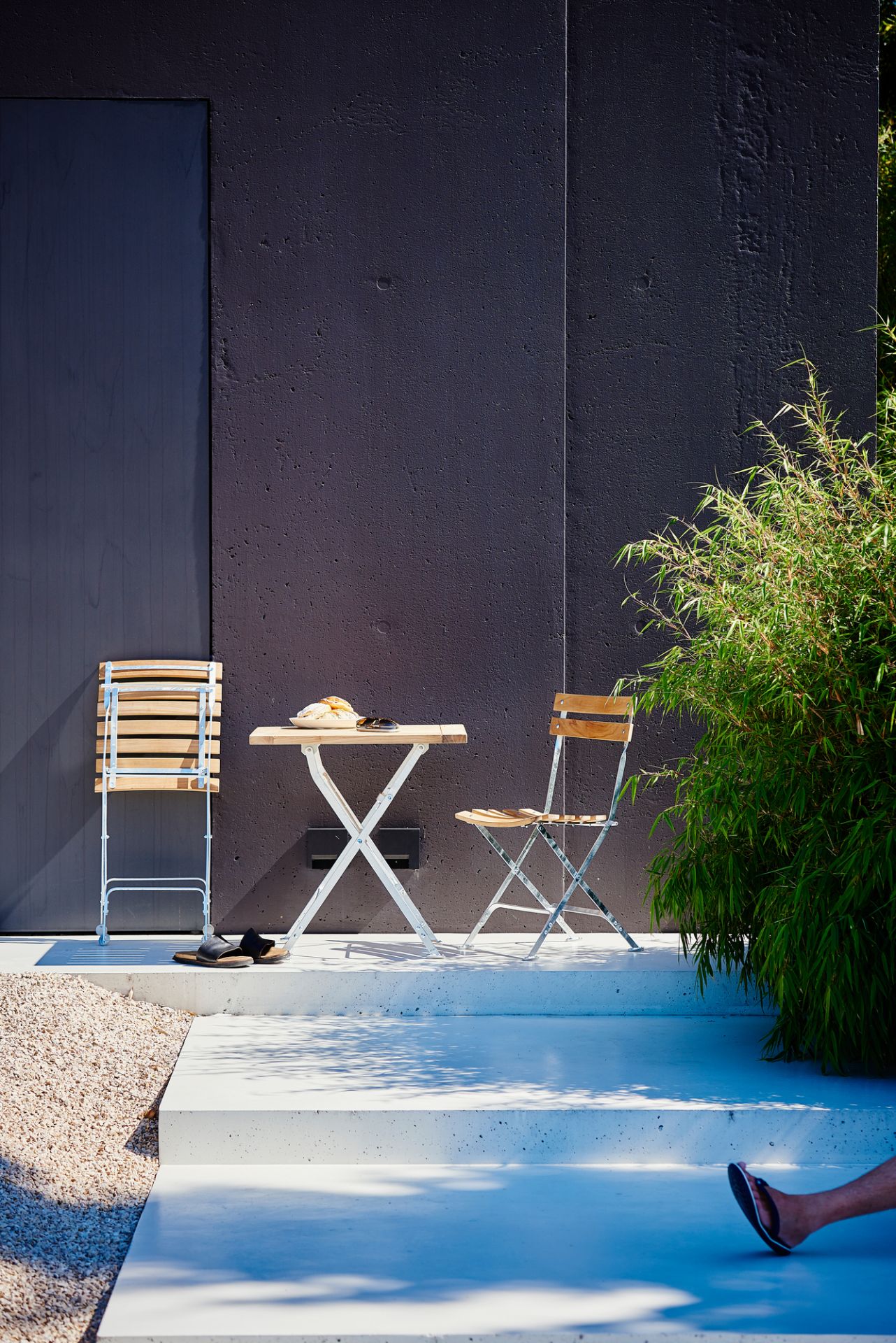 Lucca Klapptisch Natur von Jan Kurtz mit zwei Stühlen im Außenbereich.