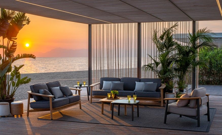 Twins Lounge Chair Sessel Outdoor Emu auf einer Terrasse mit Meerblick bei Sonnenuntergang.