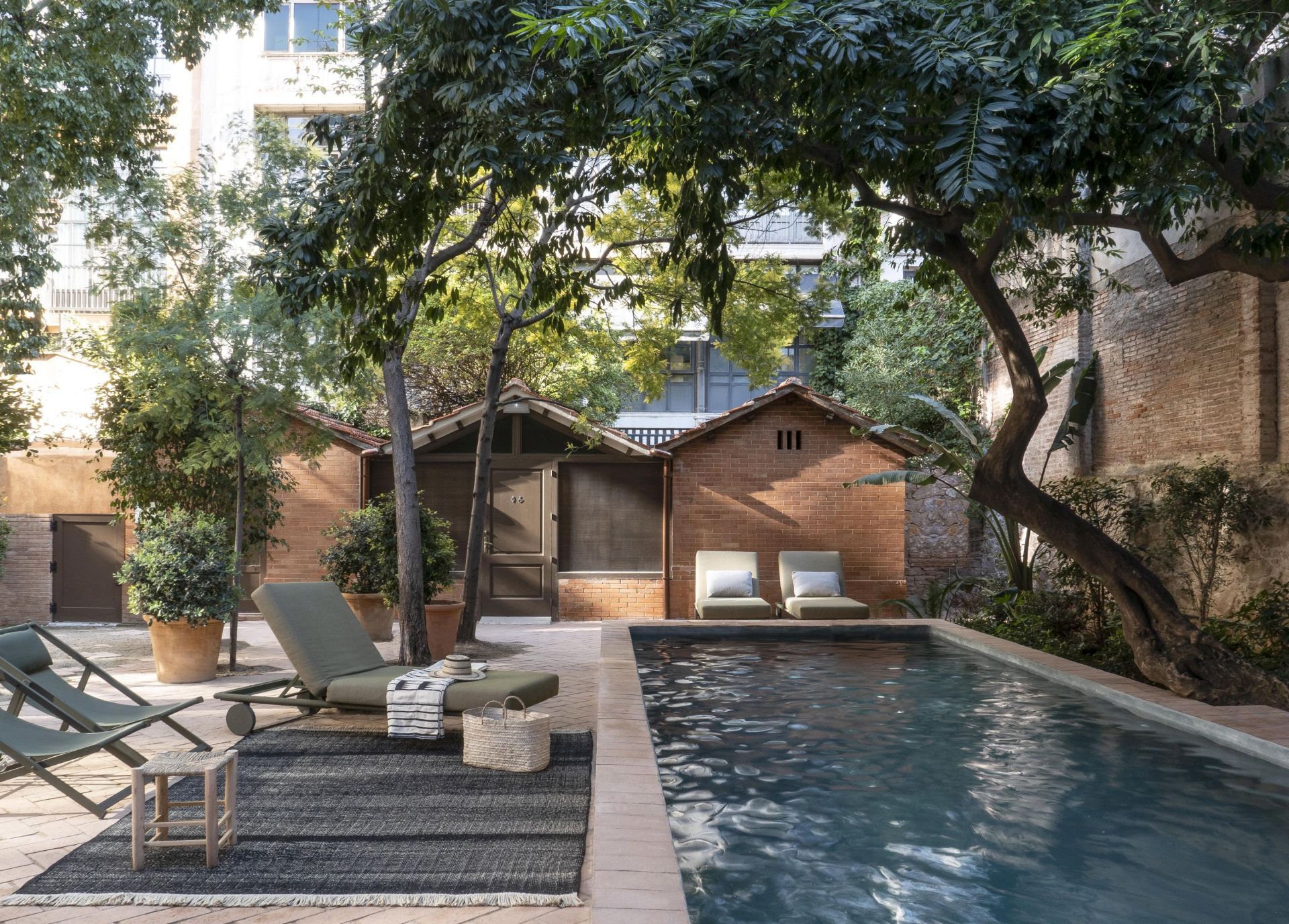 Tres Outdoor Teppich von Nanimarquina in Senf, 300x400 cm, auf Terrasse mit Pool und Liegen.