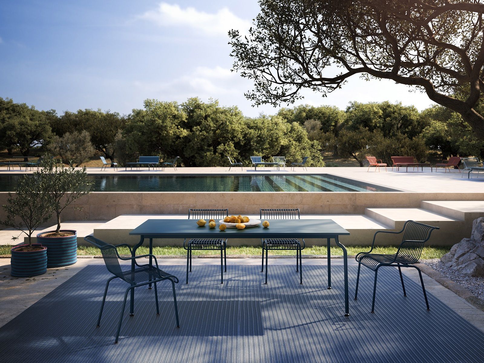 South Outdoor Carpet Teppich von Magis unter Gartenmöbeln am Pool, blauer Outdoor Teppich.