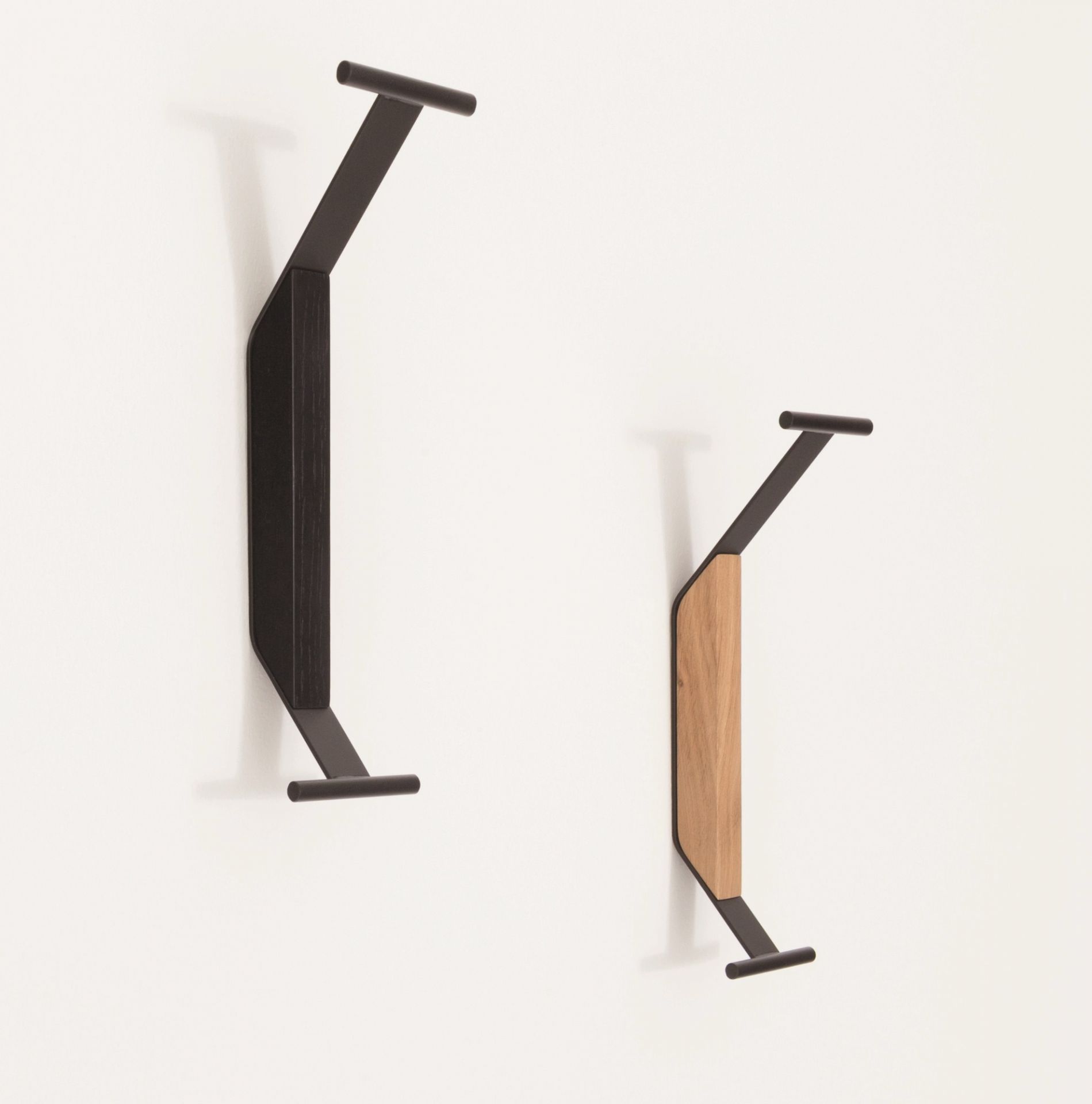 Zwei Artek Kaari Wandhaken REB 014 in Schwarz und Holz an einer weißen Wand.