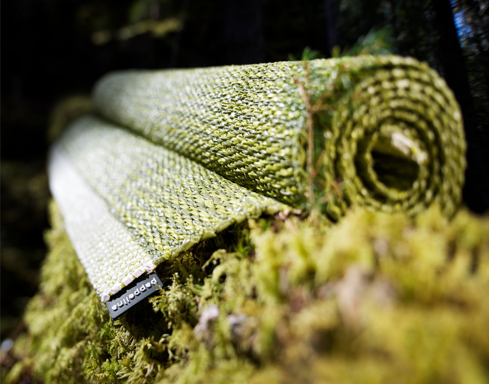 Aufgerollter Pappelina Teppich, Mono Kunststoffteppich in Grün-Weiß, 60x250 cm, Outdoor Teppich, robust und pflegeleicht.